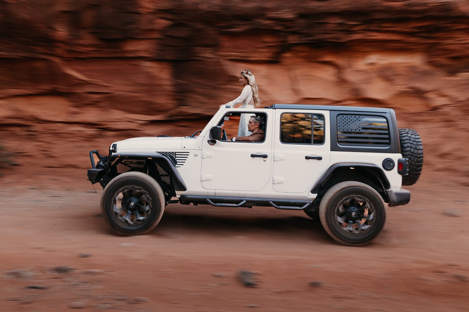 A couple drives to their wedding location in Sedona through the red rocks.