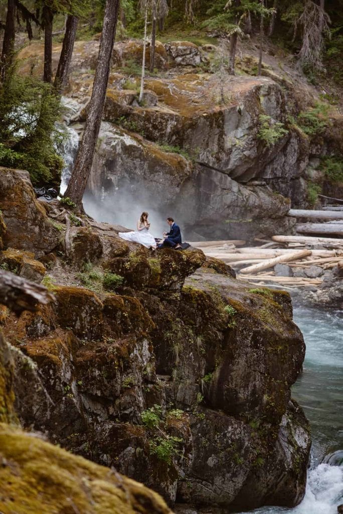 bride and groom sitting together, overlooking the river in Washington.