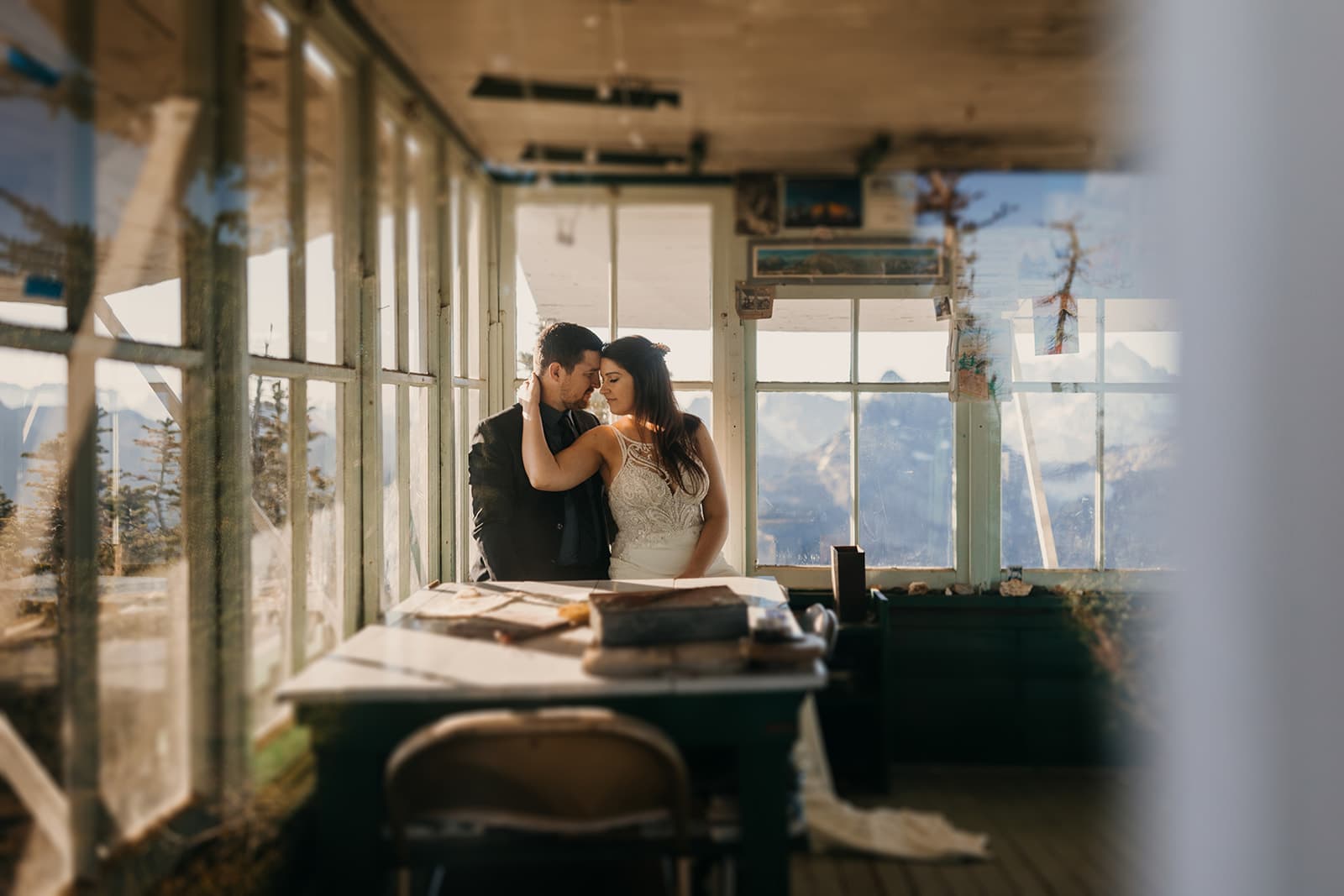 A bride holds her groom close as they sit in Winchester Mountain's fire tower on their wedding day.