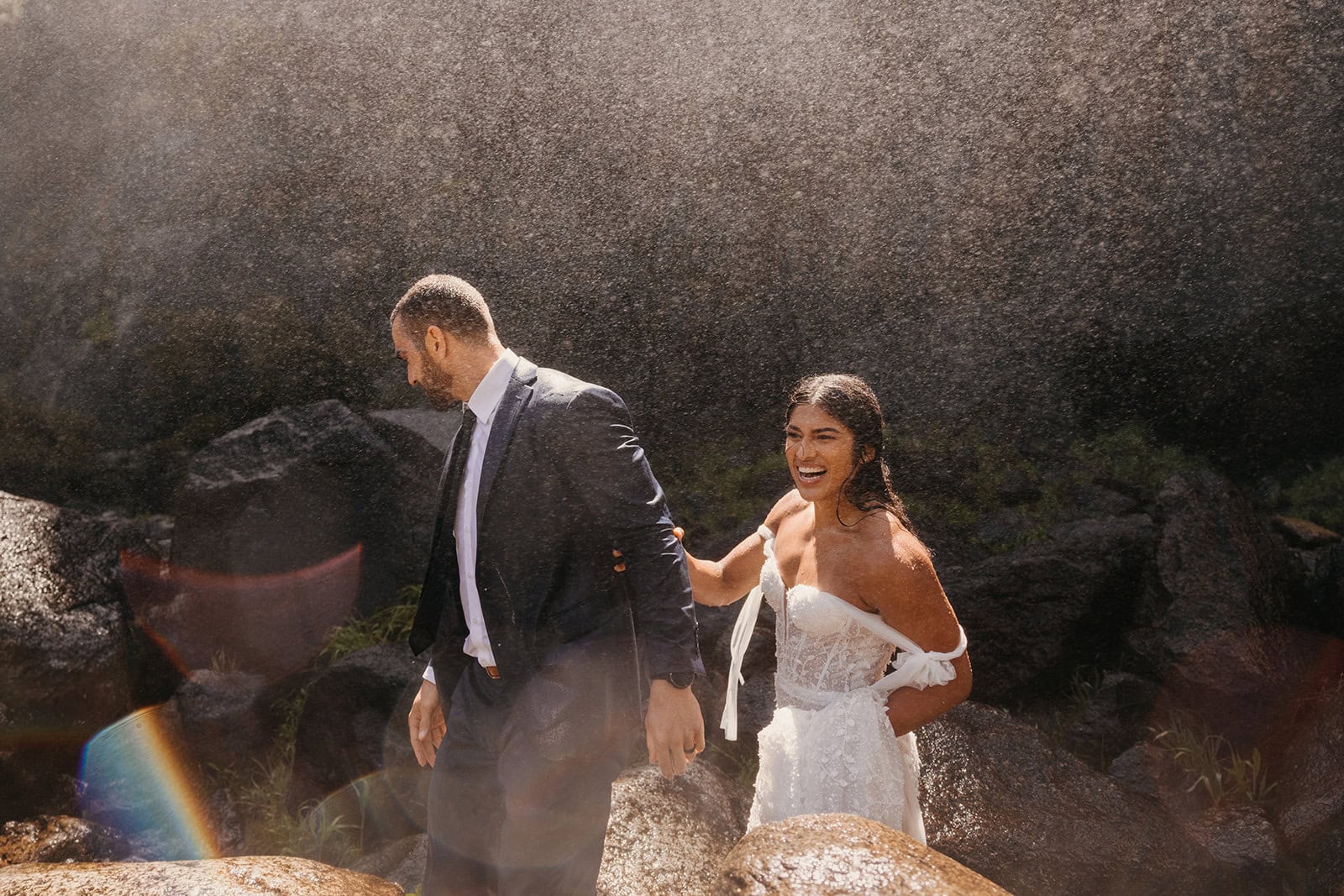 A bride smiles as she leaves a waterfall still looking flawless in her bridal hair and makeup.