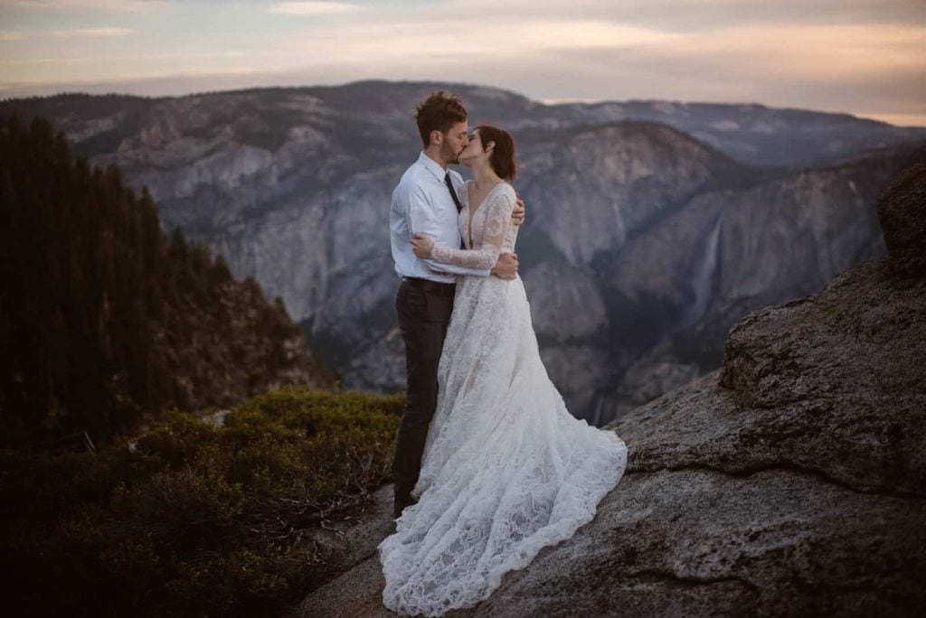 A couple shares a kiss in the morning at Glacier Point.