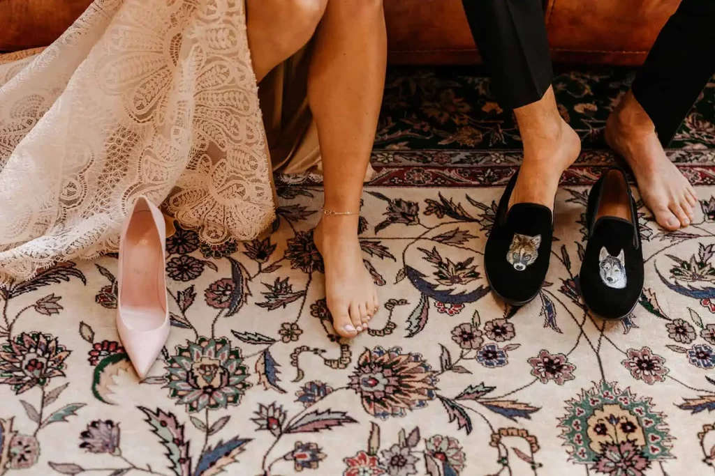 A bride and groom put their shoes on together.