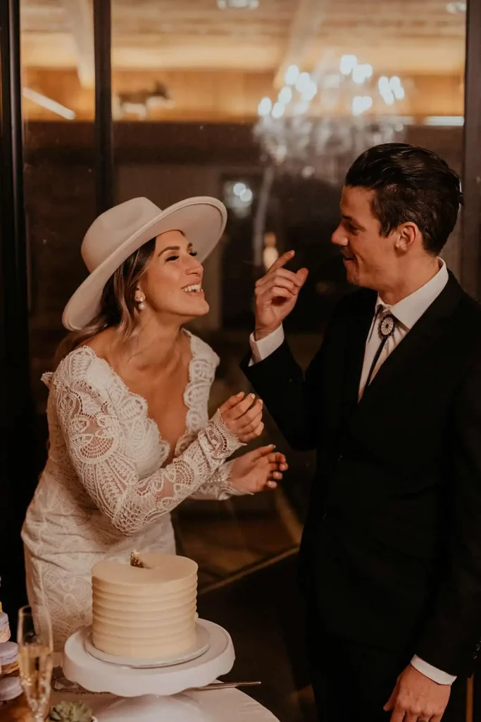 A bride and groom smile and laugh in this candid photograph.